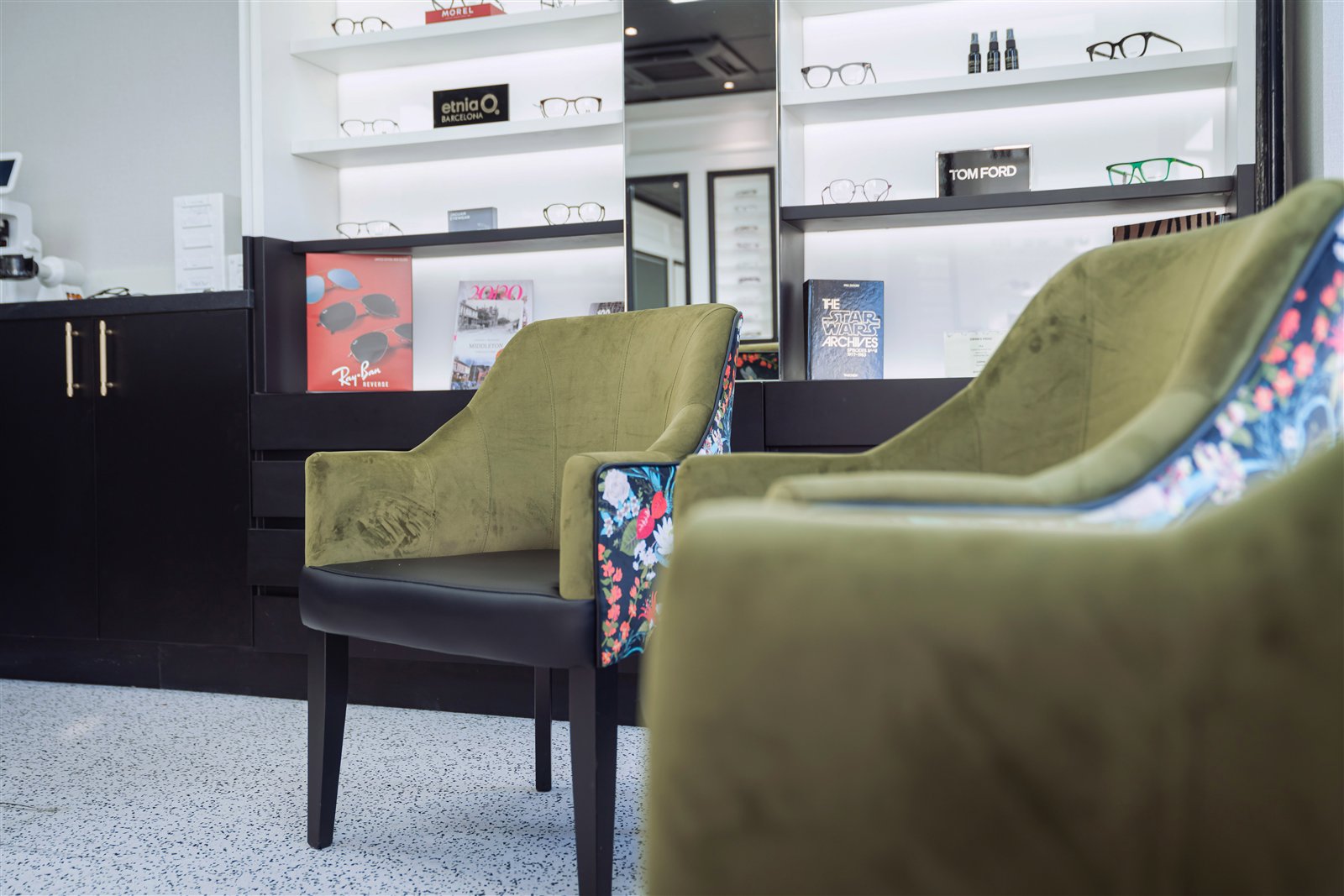 Velvet chairs in front of lit frame shelves
