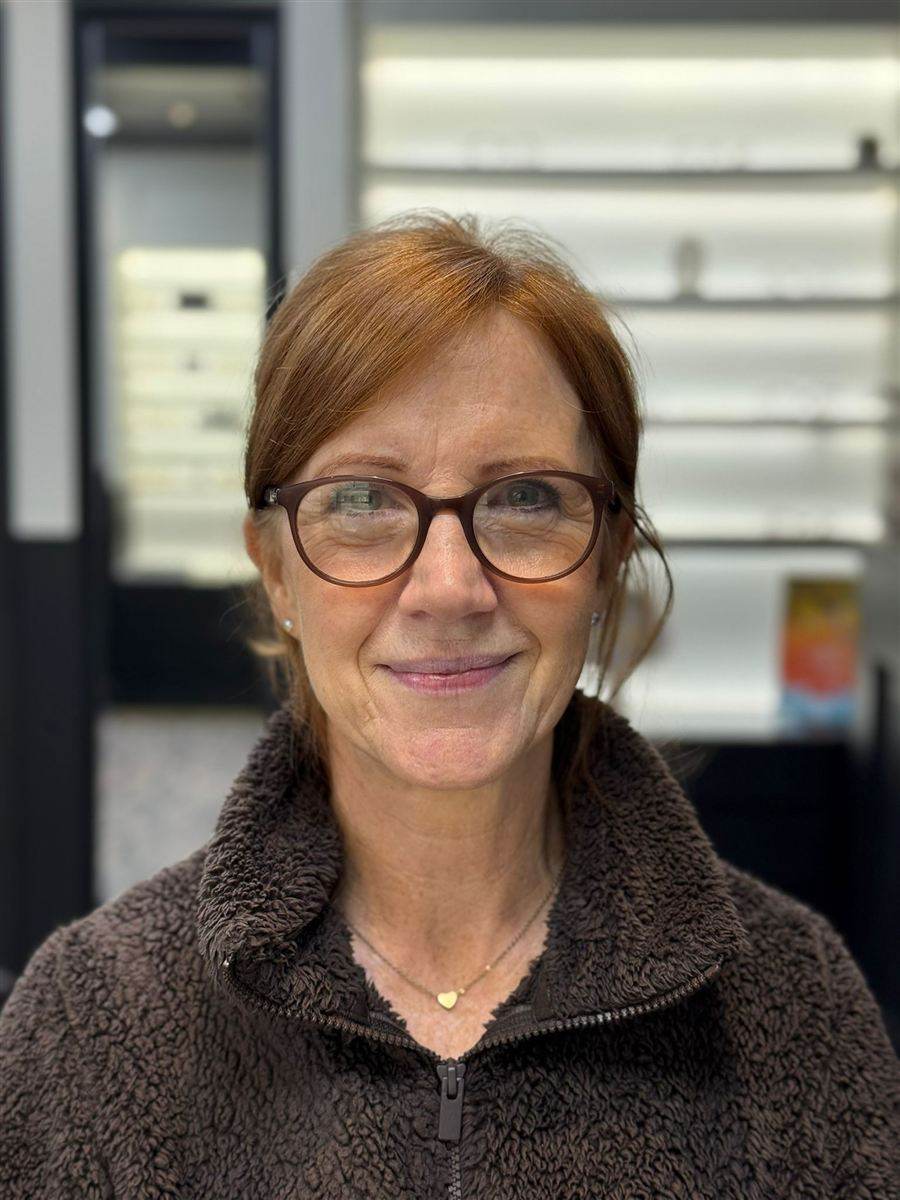 A patient with auburn hair in black glasses, chosen at Abra & Co