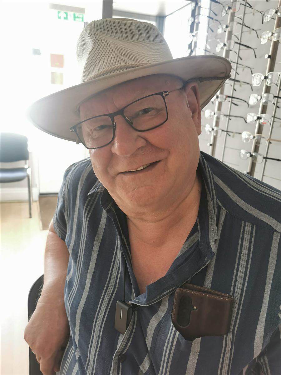 A patient in a sun hat and black glasses, chosen at Abra & Co