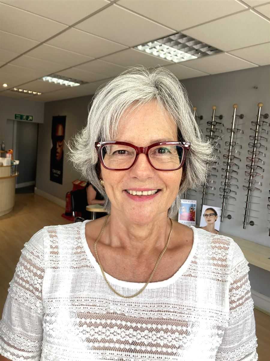 A patient with grey hair in red glasses, chosen at Abra & Co