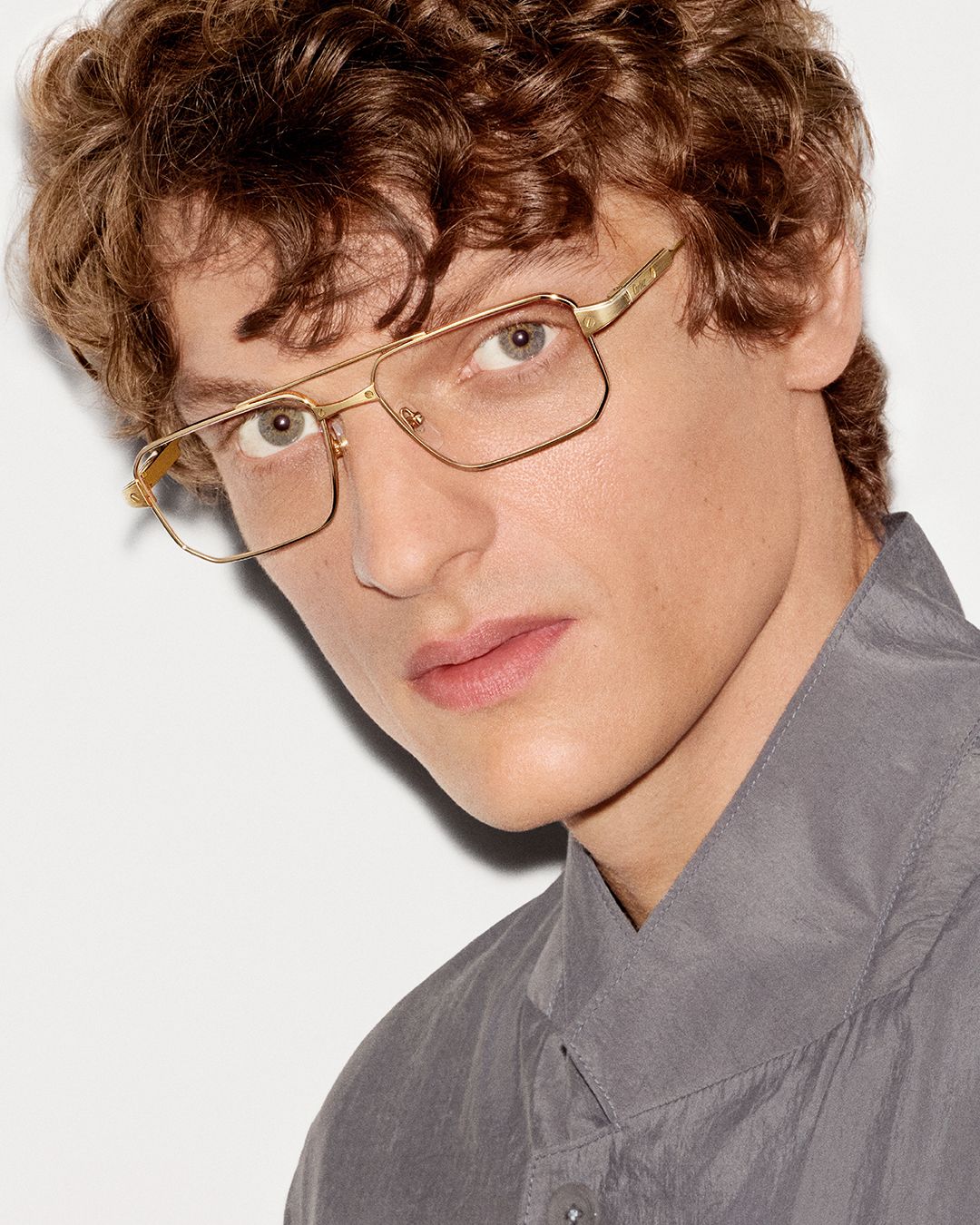 Model in gold square Cartier optical frames and a grey shirt