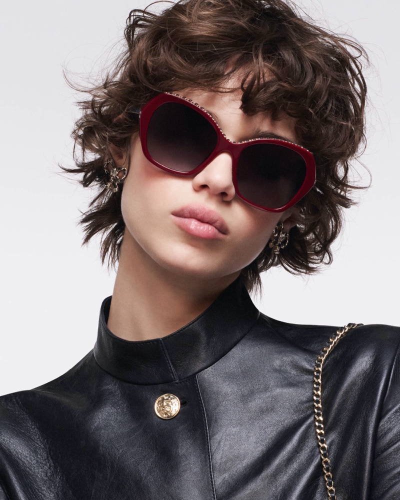 Model in burgundy Chanel butterfly sunglasses and a black leather jacket