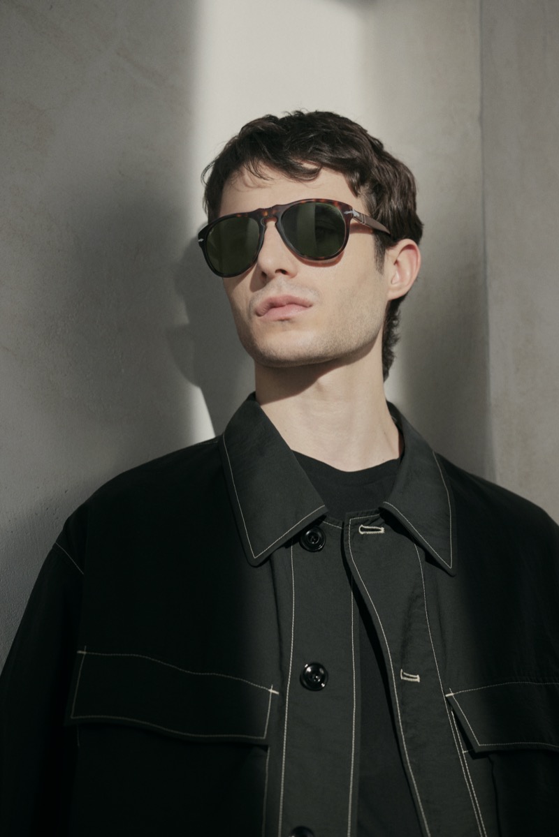 Man in tortoise Persol 649 sunglasses and a black jacket
