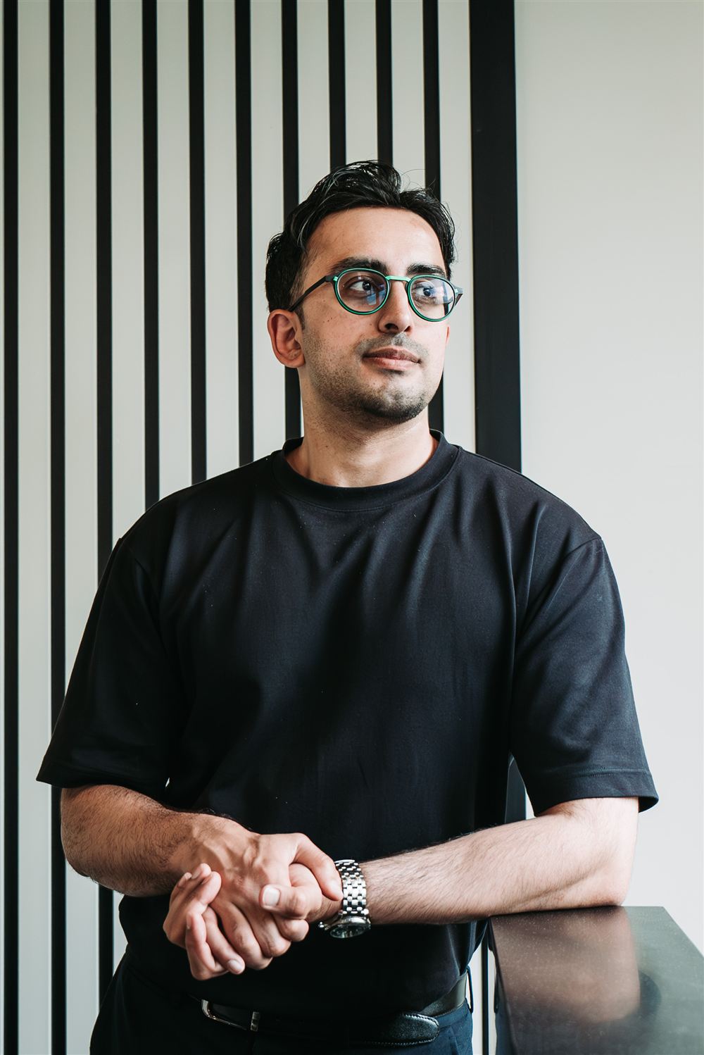 A man wearing round green glasses